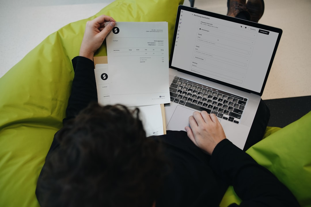A person balancing traditional documents with an online invoice system. SumUp combines convenience and efficiency for businesses.